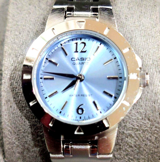 Casio quartz wristwatch with light blue analog dial and silver stainless steel band approximately 6.9 inches long