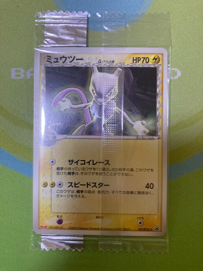 Unopened Meiji Mewtwo Delta Species 107/PCG-P Japanese promo collectible card with visible packaging wrinkles