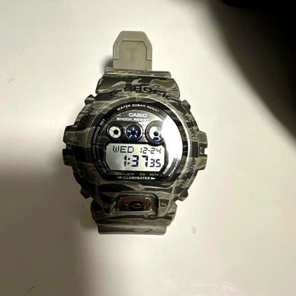 Casio G-Shock digital watch with camouflage pattern and digital display, backlight, and durable design