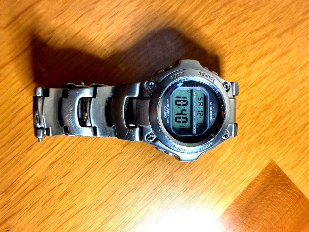 Casio G-Shock MR-G100 digital watch with stainless steel case showing time and features