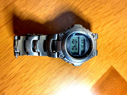 Casio G-Shock MR-G100 digital watch with stainless steel case showing time and features