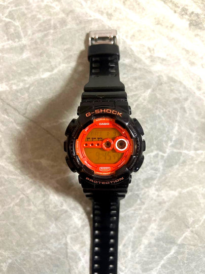 Casio G-Shock digital shock-resistant watch in black and orange with digital display and date feature