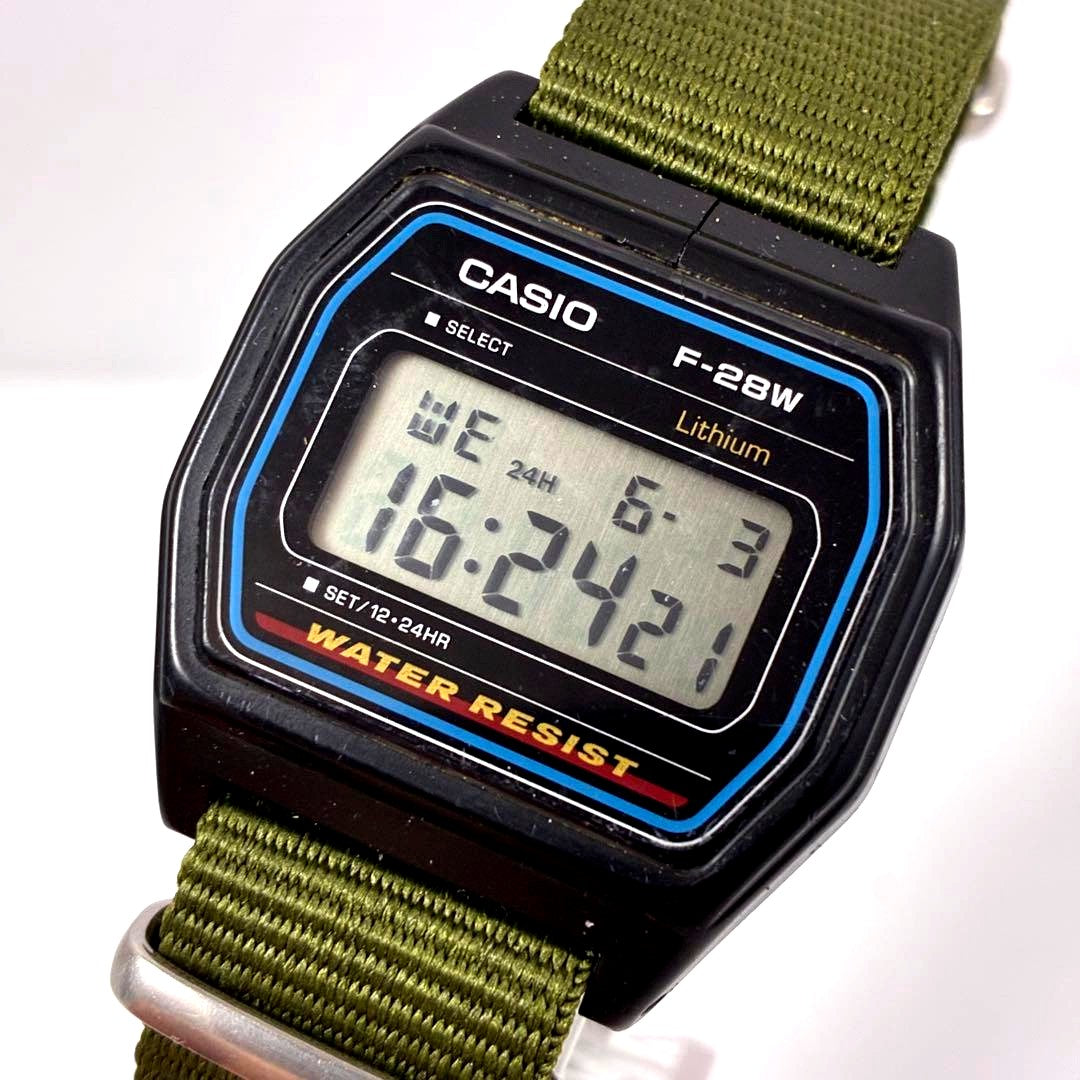 Casio F-28W digital watch with square dial and olive NATO strap showing vintage design