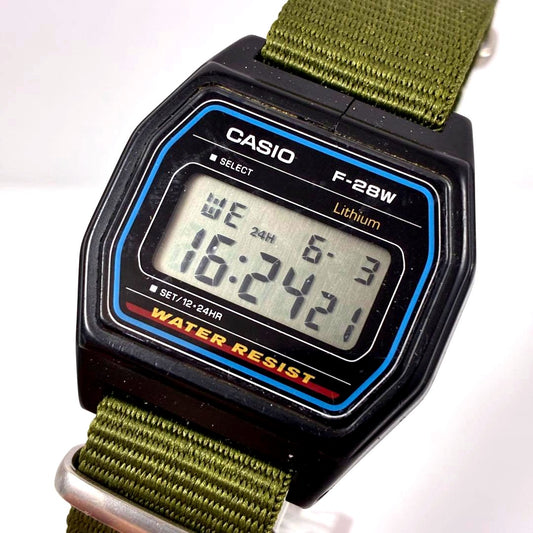 Casio F-28W digital watch with square dial and olive NATO strap showing vintage design
