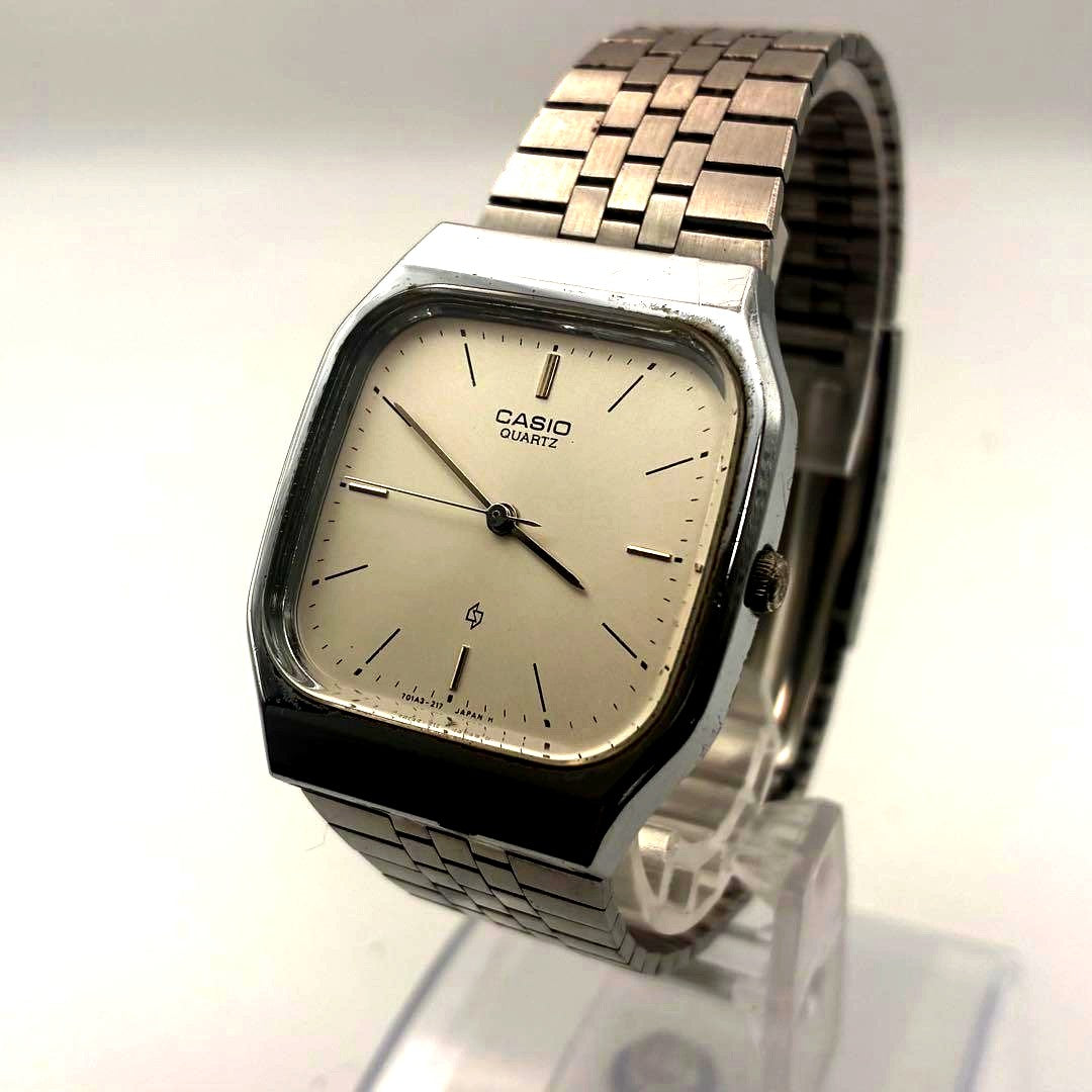 Casio MQ-303 vintage square quartz watch with silver dial and stainless steel band showing signs of wear