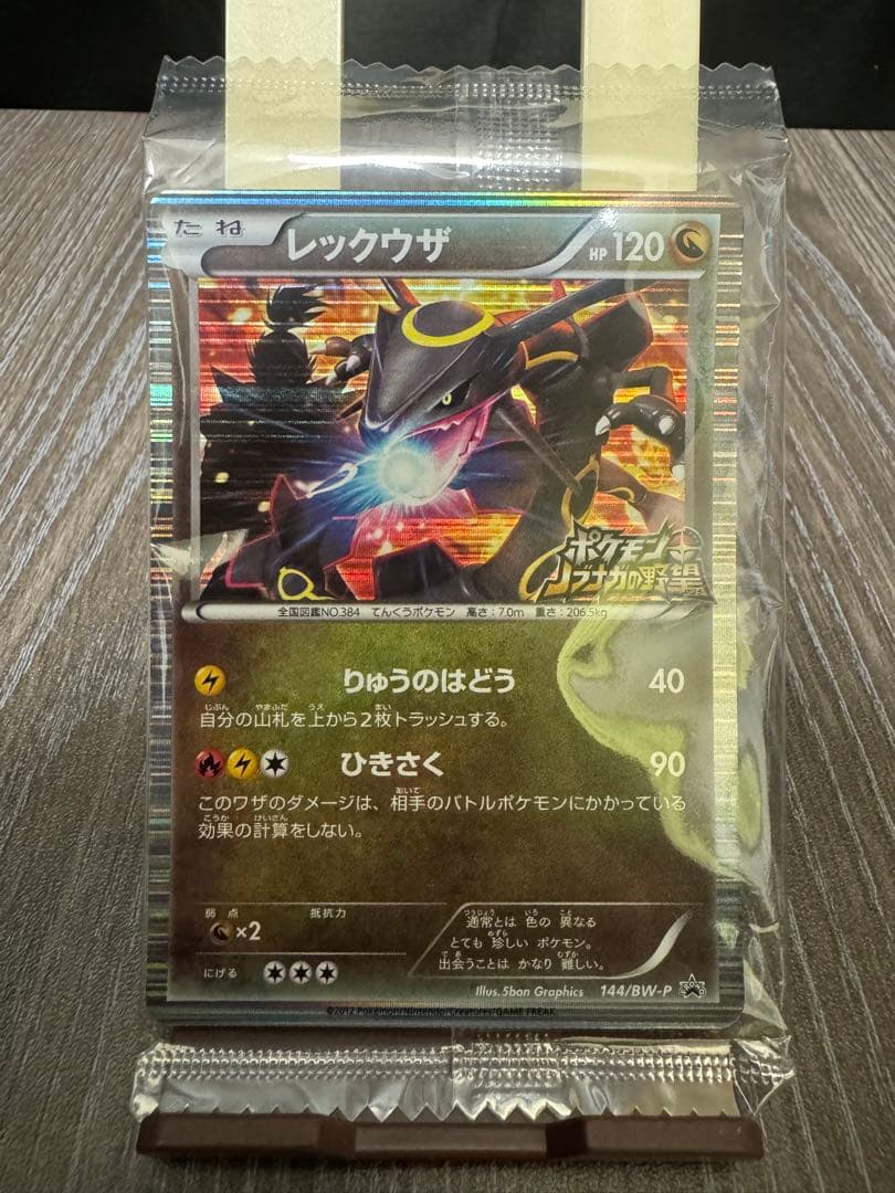 Unopened Pokemon Rekuza P Nobunaga's Ambition First Edition promotional card inside deck case with slight wrinkles on outer bag