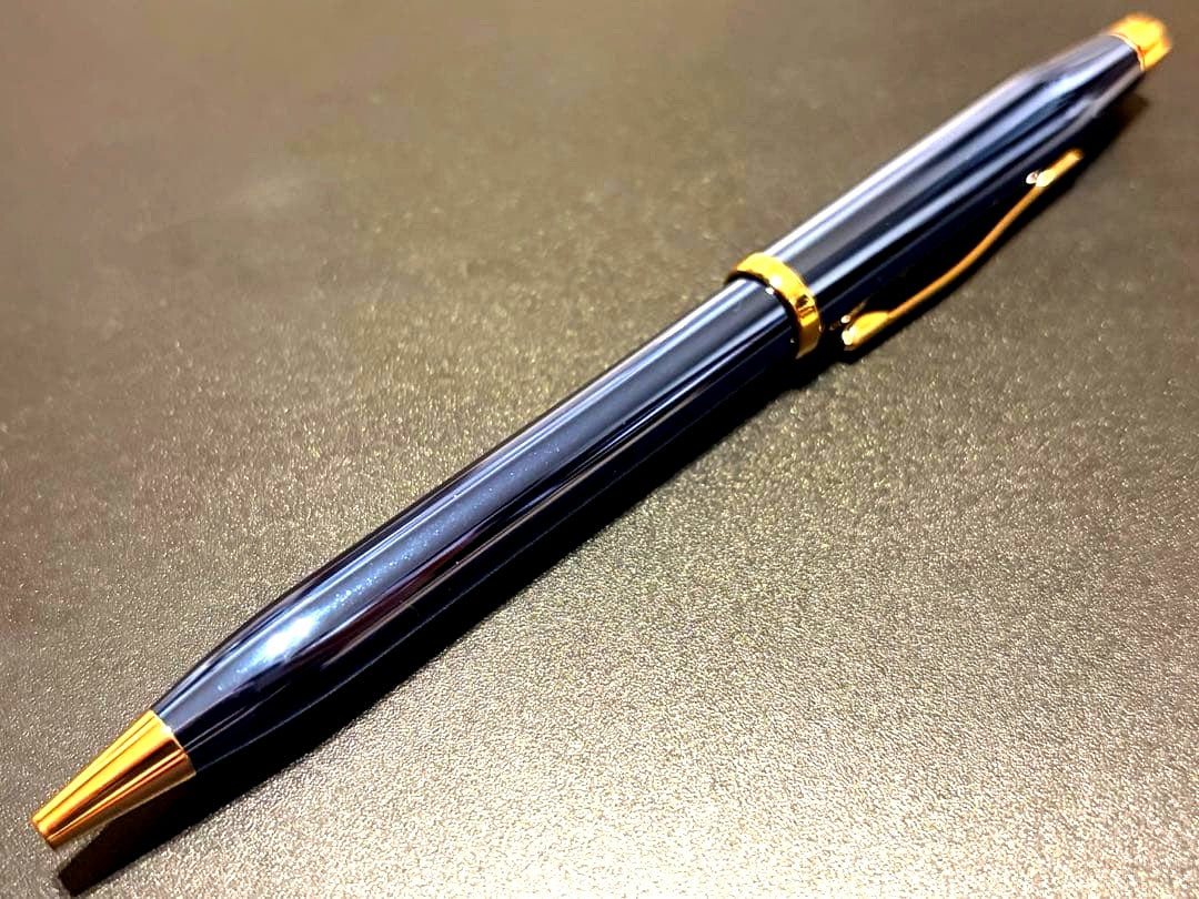 Cross Century II ballpoint pen with navy blue body and gold accents on a white background