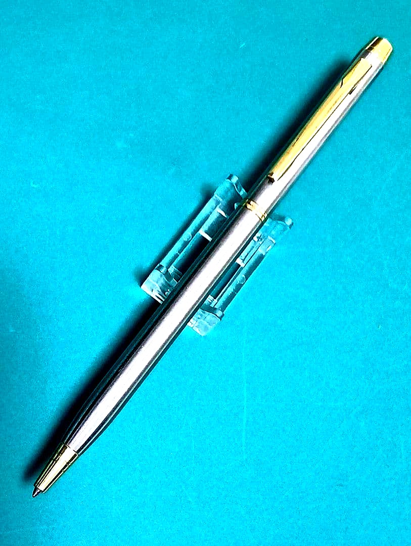 Used Unknown Brand twist ballpoint pen with silver and gold two-tone metal body and red CROSS refill