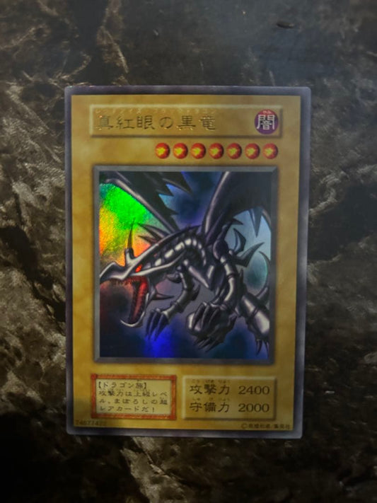 Yugi-Oh Early Ultra Rare Red Eyes Black Dragon playing card from OCG with minor wear and scratches