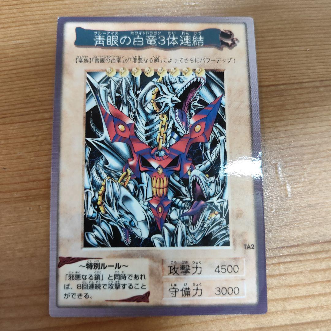 Bandai Yu-Gi-Oh! Blue-Eyes White Dragon three linked monster cards in storage sleeves showing minor wear