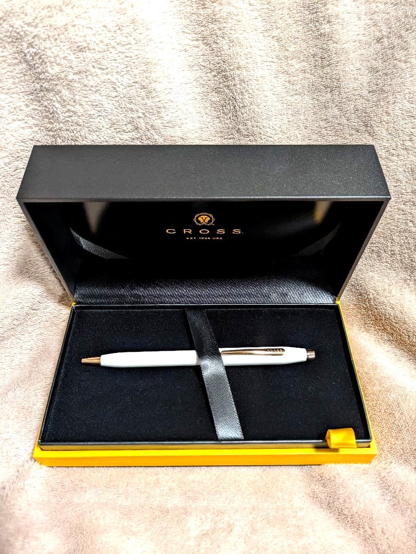 Cross white ballpoint pen with gold accents displayed alongside a gift box and two black medium tip refills