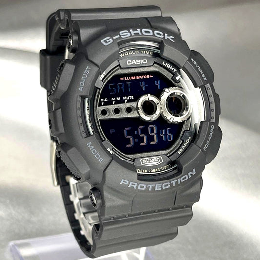 Casio G-Shock GD-100 black watch with digital display, original box, warranty card, and booklet