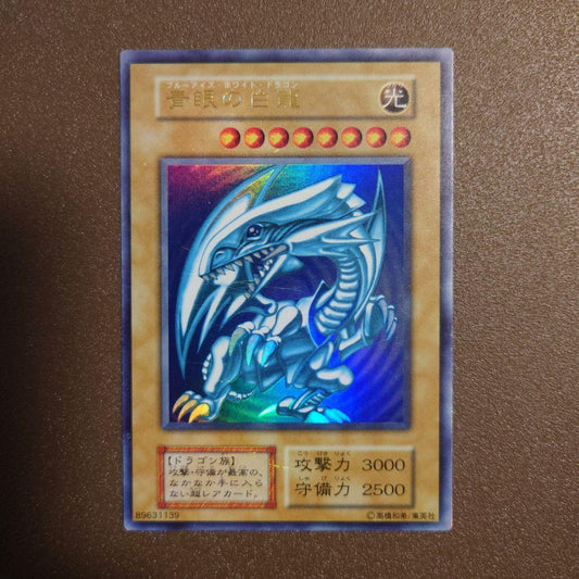 Yugioh Blue-Eyes White Dragon Ultra Rare Initial Edition monster card with minor border glitter and small scratches