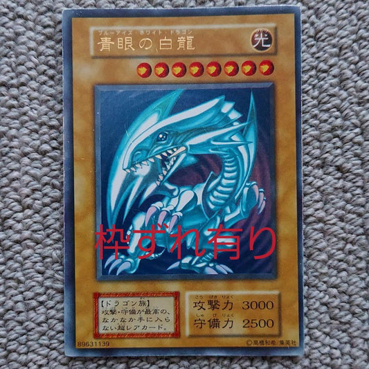 Bandai Yu-Gi-Oh Blue-Eyes White Dragon Ultra Rare Monster Card showing small scratches and frame misalignment
