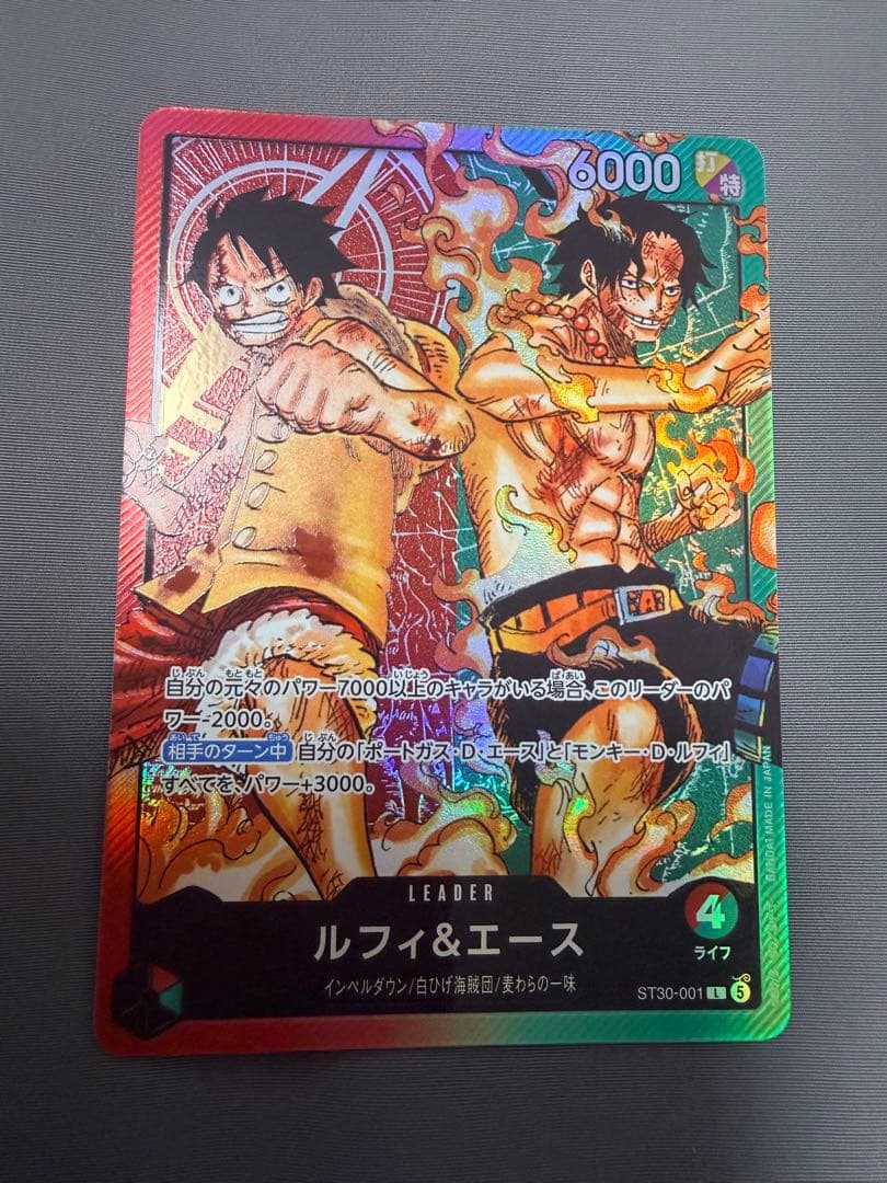 Shueisha One Piece Luffy and Ace Leader L ST30-001 collectible card in protective sleeve and hard loader