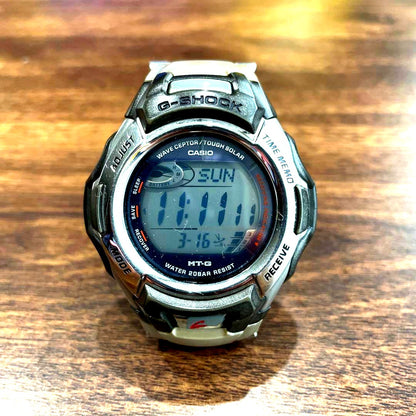 Casio G-Shock MTG-900DJ solar radio-controlled watch with black and silver design, showing time and date