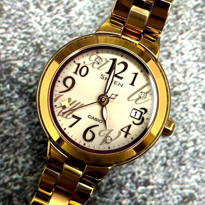 Casio Sheen ladies watch with gold round dial, linen stones, and gold-tone stainless steel band