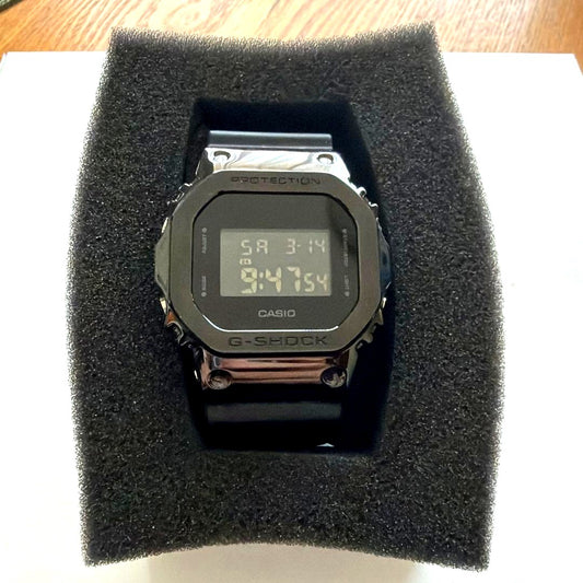 Casio G-Shock digital watch with black rubber strap and stainless steel back shown from front angle