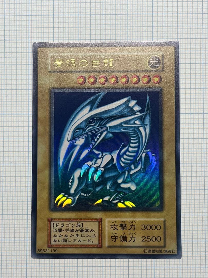 Yugioh Blue-Eyes White Dragon Ultra Rare trading card with light surface scratches and a small dent in the center