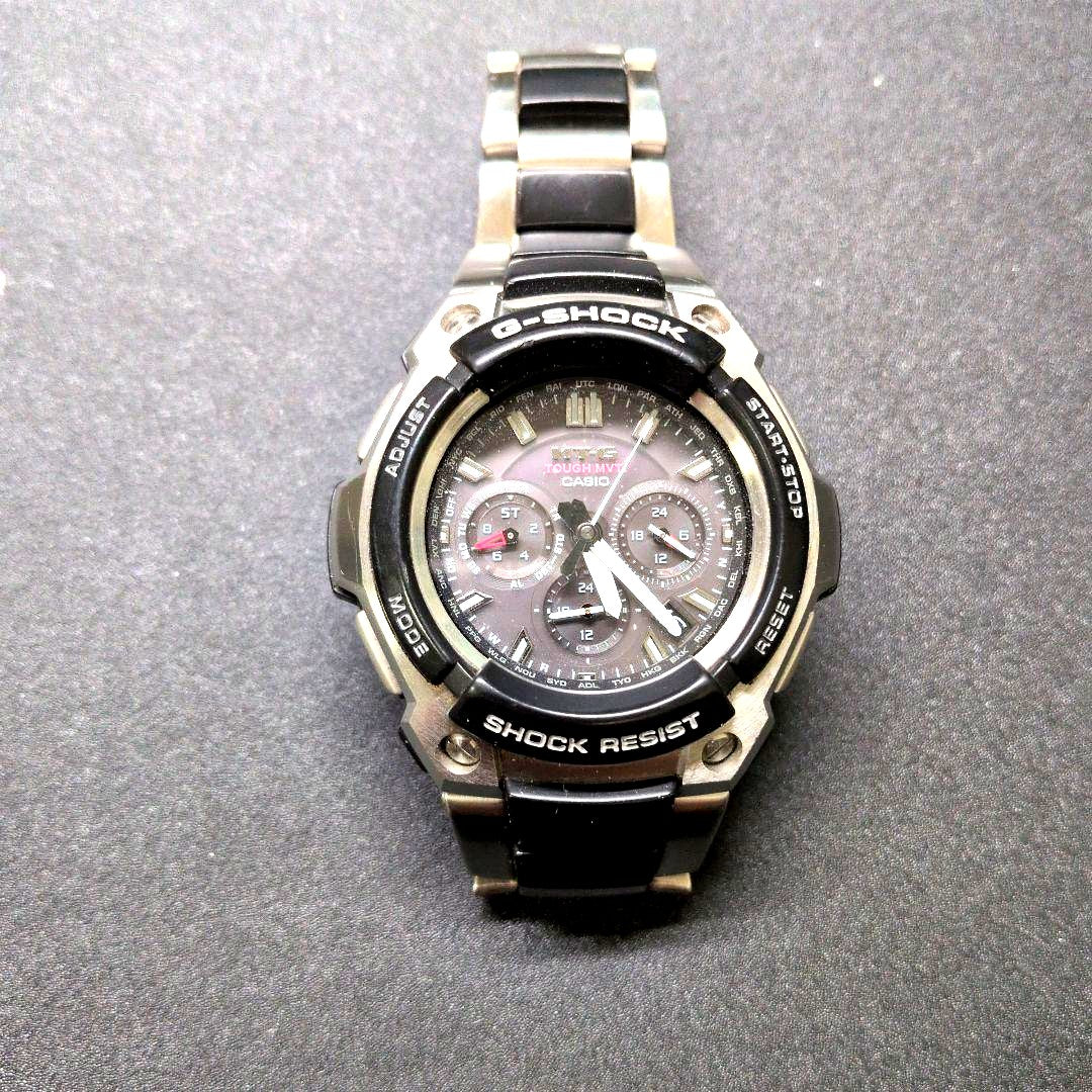 Casio G-Shock MTG-1200-1AJF watch with black dial and metal case showing minor wear and scratches