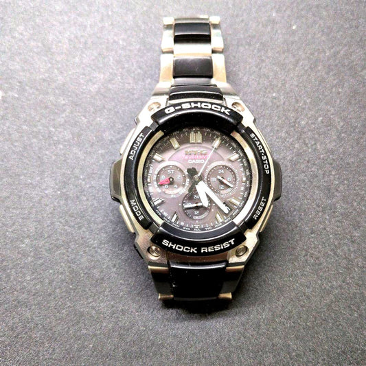 Casio G-Shock MTG-1200-1AJF watch with black dial and metal case showing minor wear and scratches
