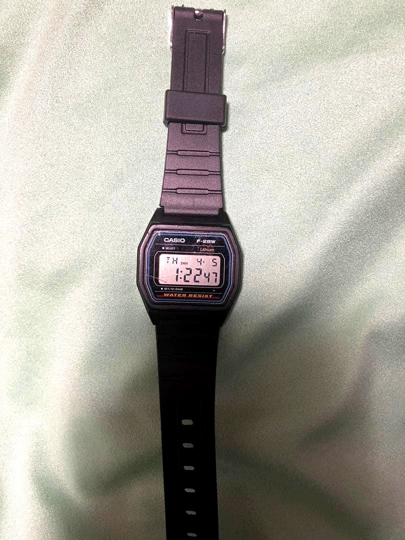 Casio F-28W digital watch showing replaced battery and band with visible wear and scratches