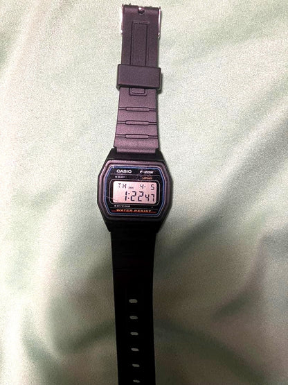 Casio F-28W digital watch showing replaced battery and band with visible wear and scratches