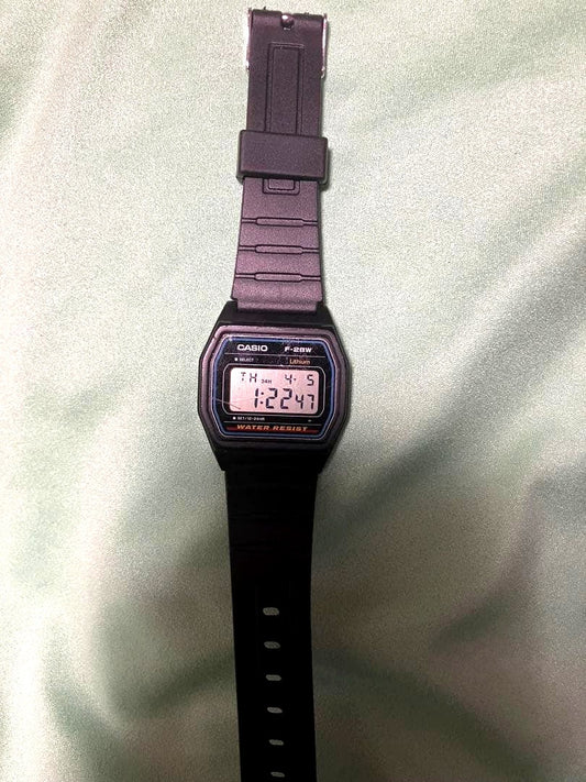 Casio F-28W digital watch showing replaced battery and band with visible wear and scratches