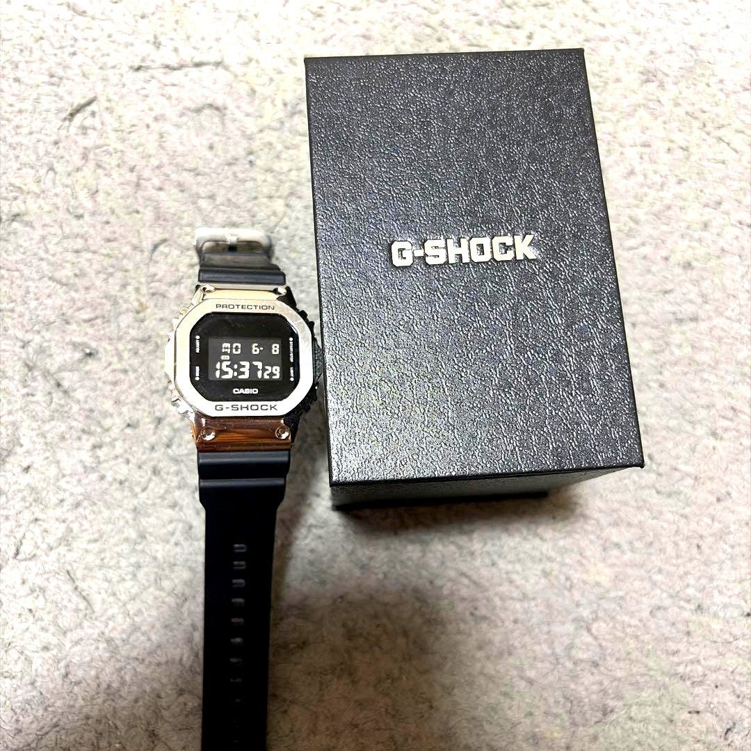 Casio G-Shock Square Digital Watch with stainless steel bezel and black resin band on white background