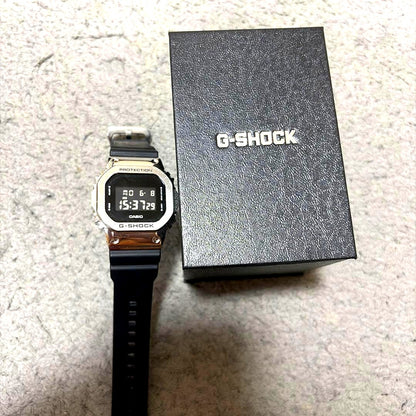 Casio G-Shock Square Digital Watch with stainless steel bezel and black resin band on white background