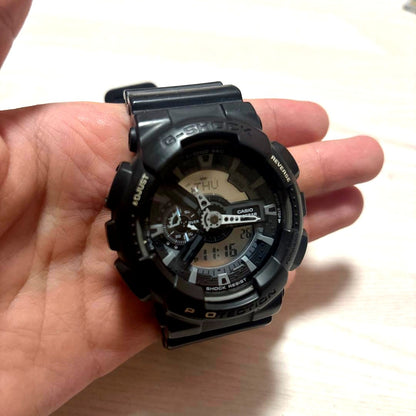 Casio G-Shock black digital watch with resin band showing time and stopwatch features