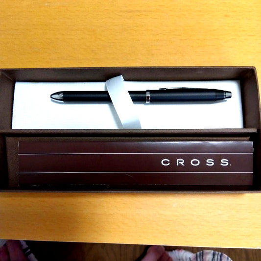Cross pen with matte black body and chrome accents shown in its box with slight wear
