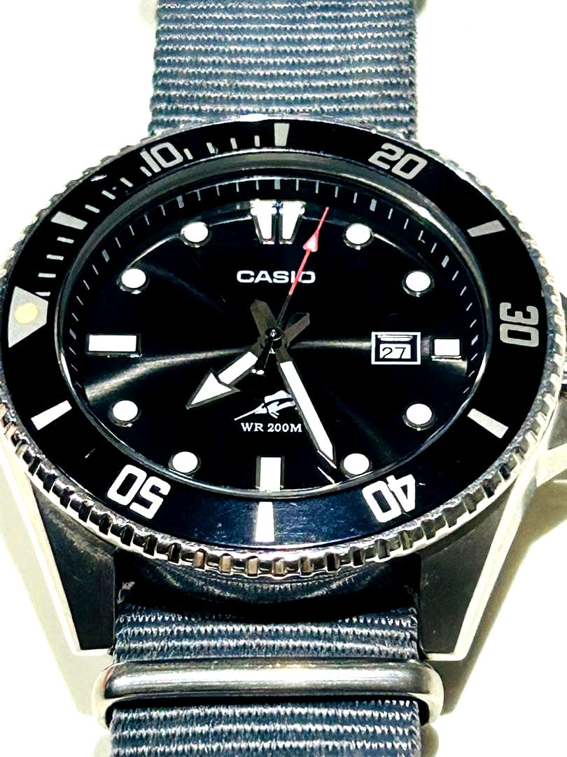 Casio WR 200M analog watch with black dial, nylon band, and date display