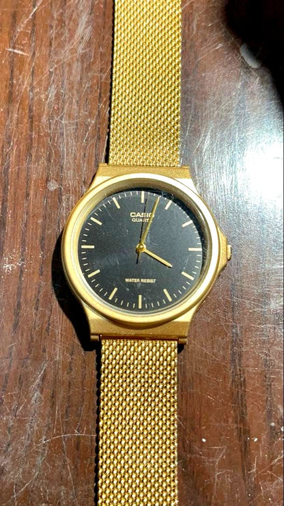 Casio MQ24MG gold wristwatch showing the watch face and gold band in used condition