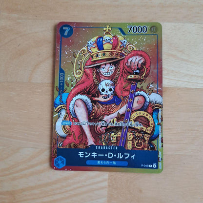 One Piece Monkey D. Luffy P-043 character card featuring Luffy with crown and slight scratch on back