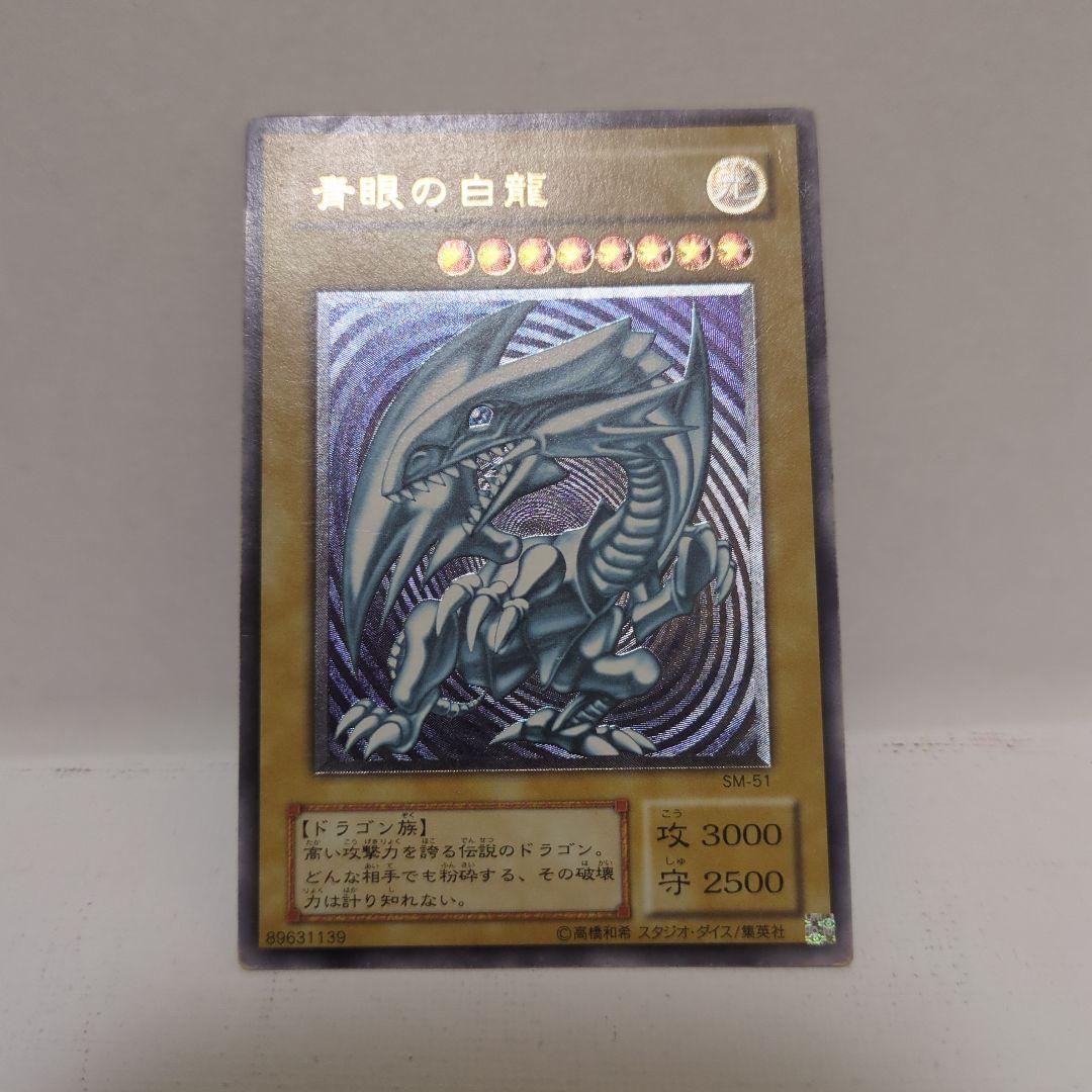 Blue-Eyes White Dragon Ultra Rare card collectible with 3000 attack, 2500 defense, chipped top and back, clean blue body